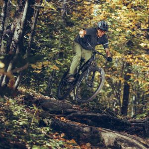 Mountain biker jumping over tree log