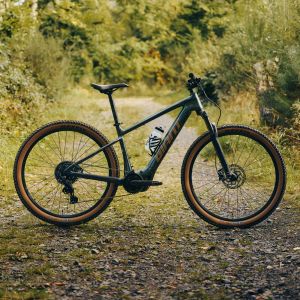 A Giant Talon E+ electric mountain bike staged on a forest dirt road.