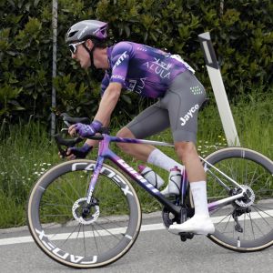 A Giant Jayco Alula pro rider coasts through a corner riding a TCR Advanced SL team bike.