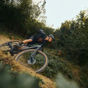 A mountain biker rips into a berm at speed on a Giant Talon E+ hardtail.