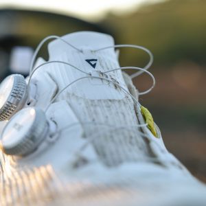A close up look at the tongue and boa dials on the Giant Charge Pro gravel/XC shoe in the woods.