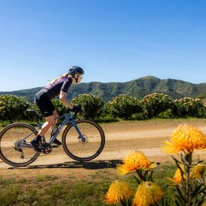 Woman riding a Liv bike on a dirt road wearing Liv Tesca Shoe.