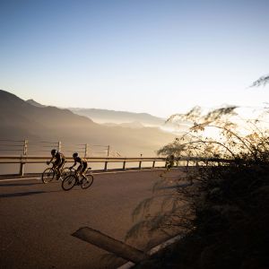 Two cyclists riding Giant TCR Advanced SL 0 with a sunset backdrop.