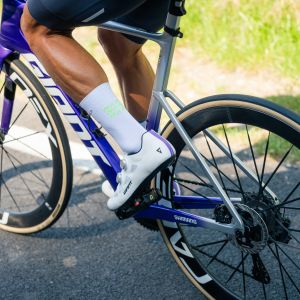 A cyclist rides by wearing Giant Surge Pro Road bike shoes.