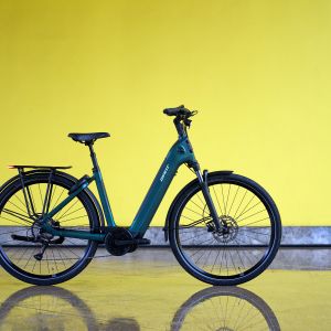 The Giant NewTour E+ from the drive side staged with a yellow background.