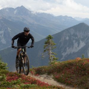 A XC mtber riding a Giant Anthem X Advanced SL over the top of a mountain trail.