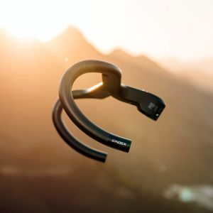 A side view of the CADEX Aero Integrated Road Handlebar with  mountain back drop.