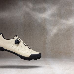 A side view of the Giant Charge 3 gravel shoe with a stylized studio background