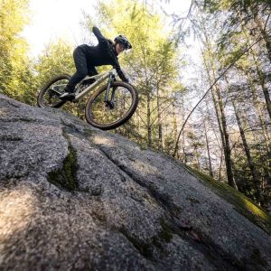 Woman riding Liv Embolden down steep rock face.