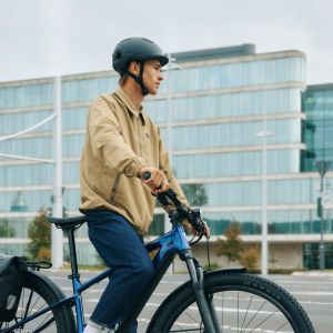 A cyclist in the city waits at a stop light on their Giant Talon E+ EX hardtail.