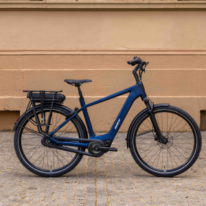 A side profile look at the Giant Entour E+ city bike standing on its kickstand on a city street.