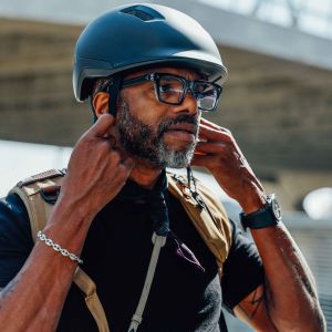 A cyclist clips the fidlock strap of his Giant Novo helmet as he prepares to ride through the city.