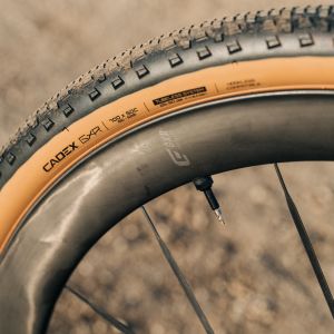 A close up look at the side tread of the CADEX GXR Tire on a dirt road.