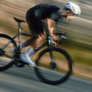 road cyclist shown blurry while riding