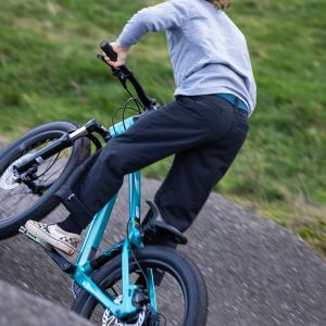 A young rider at a bike park takes a roller into a berm at speed on a Giant STP 20.