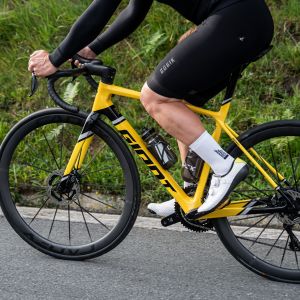 A cyclist spins by on a Giant TCR Advanced SL Legends Edition frame.