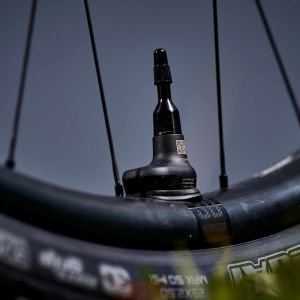 A close up view of the smart sensor air valve on the wheelset for the Giant Reign Advanced E+ enduro bike in the mountains with clouds as the backdrop.
