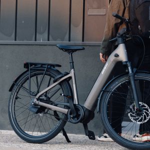 A Giant Anytour E+ electric city bike leaned against a wall in the city.