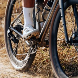 A gravel bike with CADEX GXR tires rides past on a singletrack trail.