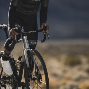 Cyclist rides out of the saddle on the tops of CADEX Aero integrated handlebar.