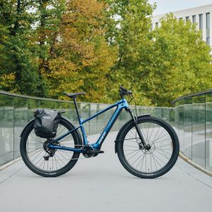 A Giant Talon E+ EX hardtail bike is staged on a city bridge with beautiful fall trees in the background.