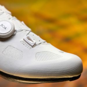 Liv Macha 1 road shoe in white on orange background.