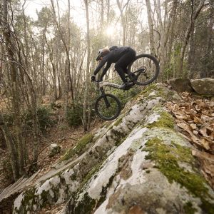 A mountain biker descends a rock slab on a Giant Stance E+ trail mountain bike.