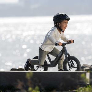 Child rides Giant Pre rCarbon strider by the coast.