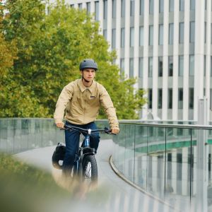 A city cyclist rides across a bridge on their Giant Talon E+ EX hardtail bike.
