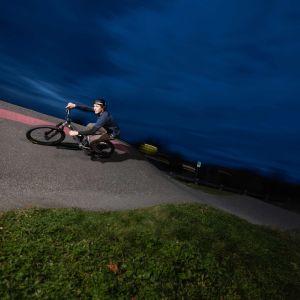 A rider on a Giant STP 26 flies through a concrete berm at a bike park.