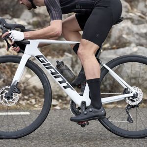 A cyclist rides by through a corner on a Giant Propel Advanced in the drops of the Giant Contact SL Aero Handlebars.