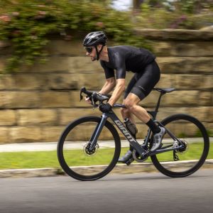 Cyclist sprints out of the saddle on a Giant Defy E+ Elite.
