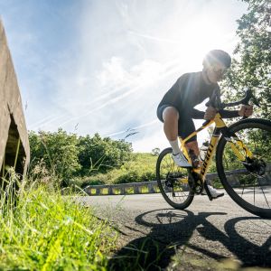 Action image of a cyclist cornering on a mountain road riding a Giant TCR Advanced Sl Legends Edition frame.