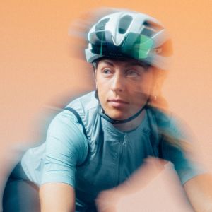 Girl wearing Liv Rev Pro Helmet on orange background.