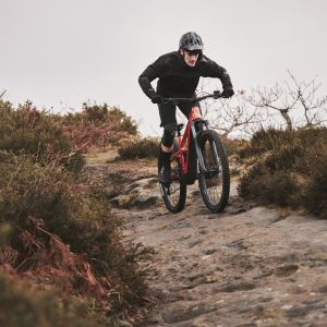 Electric mountain biker descending on rocky trail