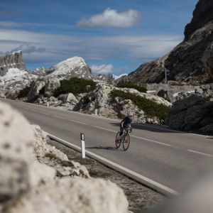 A youth road biker rides through the alps on a Giant Seek with SLR 40 1 650b wheels.