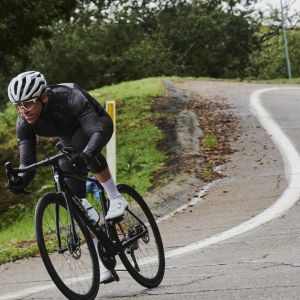 Road cyclist riding on a road in spring