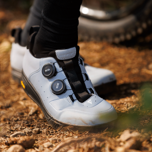 A mountain biker in the woods wears Giant Shuttle Flat boa shoes.