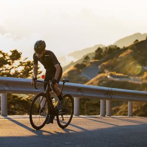 Cyclist riding up mountain road on Giant SLR handlebars.