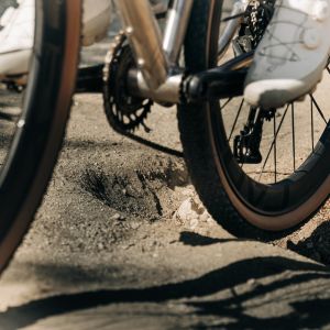 A gravel bike with CADEX GXR tires rolls over bumps on a dirt road.