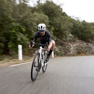 A cyclist riding a Giant Propel Advanced road bike with Giant Contact SL Aero Handlebars prepares to dive into a corner.