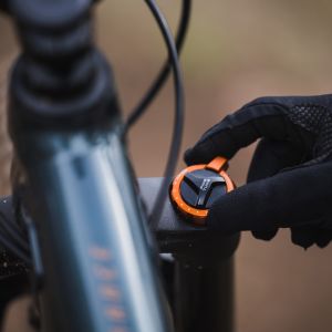 Close up of a rider adjusting the Crest TR suspension fork on his Giant Trance Advanced on the side of a trail.