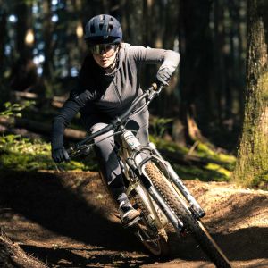 Woman wearing all black riding around a dirt turn on the Liv Embolden.