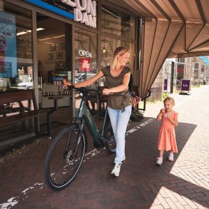 Woman walking with her Allure E+ in front of an ice cream shop