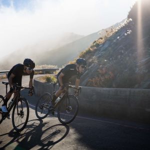 Two road cyclists ascend through a hairpin corner on Giant TCR Advanced SL 0.