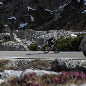A young road biker on a Giant Seek road bike rides through a high mountain valley in spring.