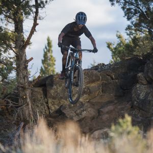 Mountain biker hits rocky drop on their Giant Trance Advanced with Crest TR Fork.