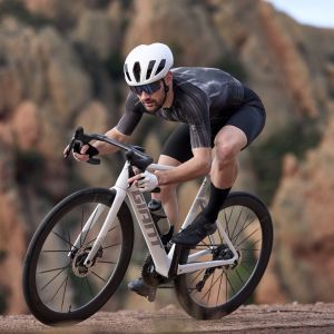 A cyclist wearing a Giant Pursuit aero helmet descends through a corner on a Giant Propel Advanced Pro road bike.