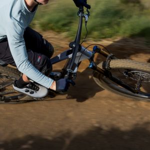 A mountain biker takes a berm at speed with a mountain bike fitted with Contact SLR Trail Integrated Handlebars.