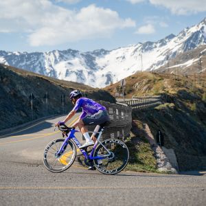 A cyclist rides a switchback up into the mountains wearing Giant Surge Pro Road bike shoes.